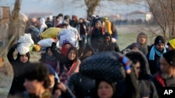 Image Description Migrants walk to reach Pazarakule border gate, Edirne, Turkey, at the Turkish-Greek border, March 1, 2020. 