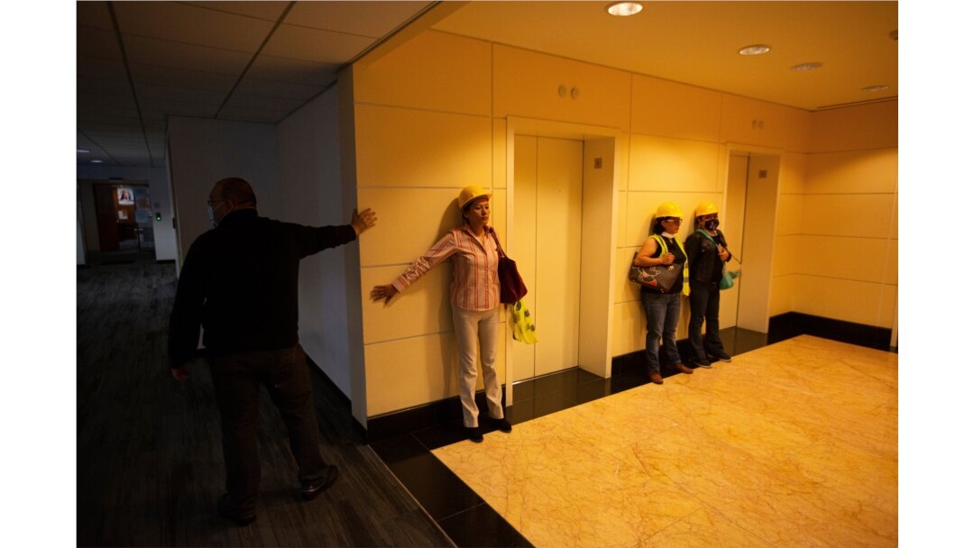 People brace themselves against a wall during an earthquake, in Mexico City, June 23, 2020.