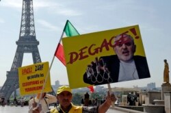 Demonstrators of the National Council of Resistance of Iran demonstrate on the Trocadero square Friday, Aug. 23, 2019 in Paris as Iranian Foreign Minister Javad Zarif is in France. Poster reads: get out.