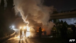 Firefighters extinguish a burning UNIFIL vehicle, set ablaze by protesters, on the road leading to Beirut's international airport on Feb. 14, 2025. 