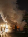 Firefighters extinguish a burning UNIFIL vehicle, set ablaze by protesters, on the road leading to Beirut's international airport on Feb. 14, 2025. 