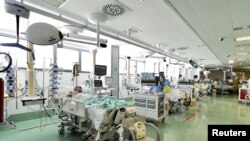 FILE - Patients suffering from the coronavirus disease are seen in the intensive care unit at the Papa Giovanni XXIII hospital in Bergamo, Italy, May 12, 2020.