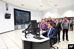 In this photo released by Thailand's Provincial Electricity Authority, Thailand's Deputy Prime Minister Anutin Charnvirakul shuts down electricity supplies to five locations in Thailand-Myanmar border at the Provincial Electricity Authority headquarters in Bangkok, Feb. 5, 2025.