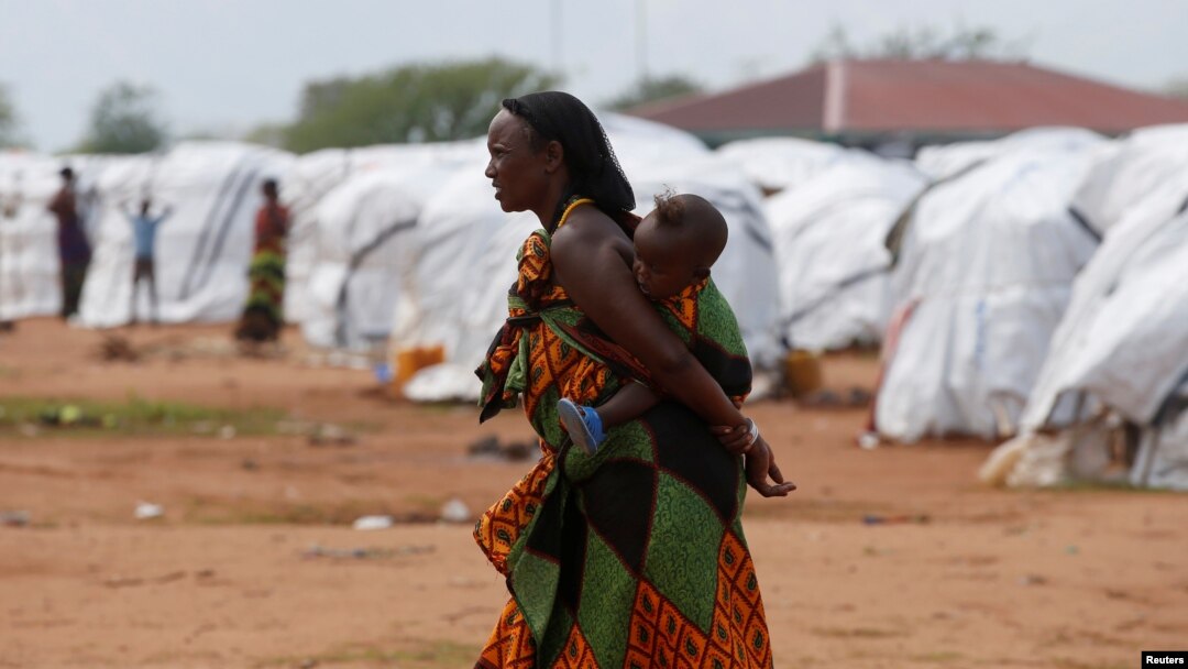 FILE - An Ethiopian asylum seeker carries an infant in the Dambala Fuchana refugee camp near the Ethiopian-Kenyan border town of Moyale, Kenya, March 27, 2018.
