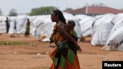 FILE - An Ethiopian asylum seeker carries an infant in the Dambala Fuchana refugee camp near the Ethiopian-Kenyan border town of Moyale, Kenya, March 27, 2018.