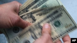 ARHIVA - Prebrojavanje novačanica od 20 dolara (Foto: AP/Elise Amendola)