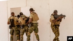 In this Feb. 18, 2020, photo, Nigerian Navy Special Boat Service troops exercise under the supervision of British special forces during U.S. military-led annual counterterrorism exercise in Thies, Senegal. 