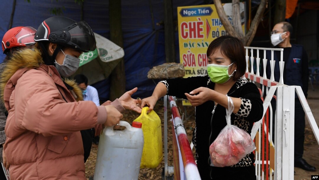Người dân truyền nhau những can nước tại một chốt kiểm soát ở Sơn Lôi. 
