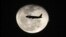 A passenger jet flies in front of the moon in Bogota, Colombia on Nov. 1, 2012. 