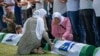 Dua orang perempuan menangis di tengah persiapan pemakaman korban yang baru diidentifikasi di pemakaman peringatan di Potocari dekat Srebrenica, Bosnia, Minggu, 11 Juli 2021. (Foto: AP)