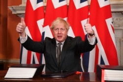 Britain's Prime Minister Boris Johnson gives a thumbs-up gesture after signing the EU-UK Trade and Cooperation Agreement at 10 Downing Street, London, Dec. 30, 2020.