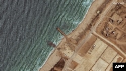 资料照片：这张卫星图像显示了2024年5月29日美国在加沙地带海岸建造的三叉戟码头的剩余部分，此前恶劣天气将其破坏。(法新社照片)
