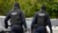 Police wearing balaclavas hold a battering ram used to break down a door outside the residence of internet influencer Andrew Tate during an early morning police search raid, on the outskirts of Bucharest, Romania, Aug. 21, 2024. 
