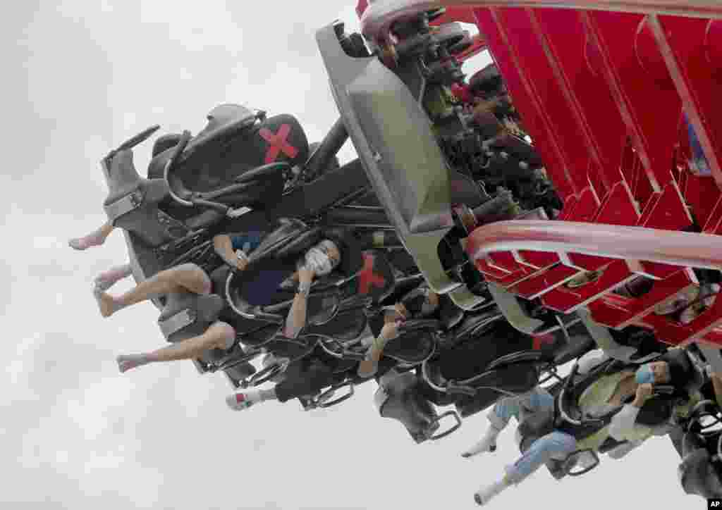 Visitors wear their face masks ride the &quot;Vortex&quot; roller coaster at the recently reopened Siam Amazing Park in in Bangkok, Thailand