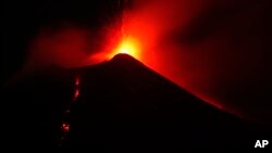 In this photo taken late on Aug. 23, 2018, Mount Etna volcano spews lava during an eruption. 