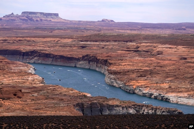 FILE - Boats move along Lake Powell along the Upper Colorado River Basin, June 9, 2021, in Wahweap, Arizona. (AP Photo/Ross D. Franklin, File)