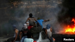 Pengunjuk rasa Palestina mengendarai mobil saat mereka bersiap untuk protes terhadap pemukiman Israel di Beita di Tepi Barat yang diduduki Israel, 22 Juni 2021. (Foto: REUTERS/Mohamad Torokman)