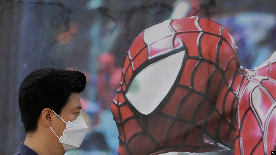 Seorang pria Korea Selatan mengenakan masker pent-up hidung dan mulutnya untuk tindakan preventive terhadap virus MERS, melewati poster pagelaran musik bergambar Spider-Man di Seoul, Korea Selatan (10/6). 