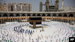 Jemaah haji yang jumlahnya dibatasi karena pandemi Covid-19, bergerak mengelilingi Ka'bah berbentuk kubus dengan menjaga jarak, dalam ritual pertama pelaksanaan haji, di Mekkah, Arab Saudi, 29 Juli 2020. (Saudi Media Ministry via AP)