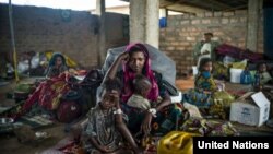 A 19-year-old woman and her children wait for their first hot meal in over two months at the Dosseye refugee camp in Chad. They arrived the previous day after fleeing violence in C.A.R.