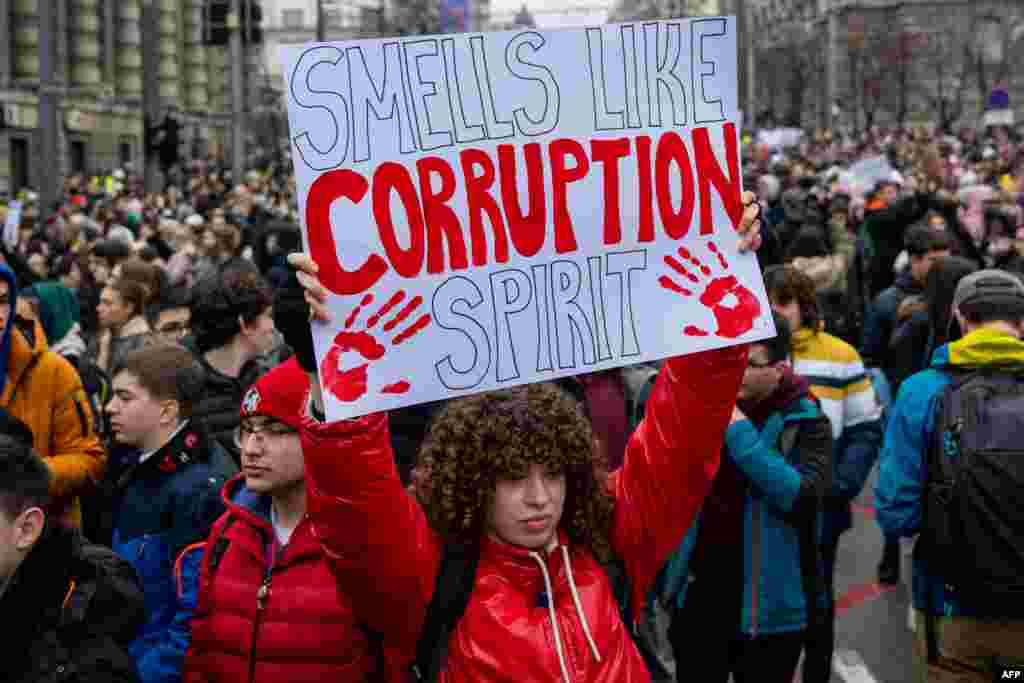 A woman holds a placard reading "Smells like corruption spirit" during a demonstration in central Belgrade on Jan. 24, 2025, after student protest organizers called for a general strike over the fatal collapse of a train station roof in November.