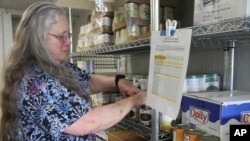 Rose Carney organizes supplies at the food pantry at Harvest Christian Fellowship Church in Eagle River, Alaska, on April 17, 2023.