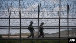 FILE - South Korean soldiers patrol along a barbed wire fence in the Demilitarized Zone (DMZ) separating North and South Korea, on the South Korean island of Ganghwa, April 23, 2020.