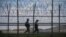 FILE - South Korean soldiers patrol along a barbed wire fence in the Demilitarized Zone (DMZ) separating North and South Korea, on the South Korean island of Ganghwa, April 23, 2020.
