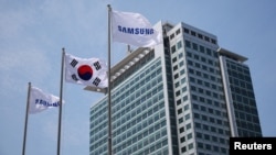 FILE - Flags with the logo of Samsung Electronics are seen during a media tour at Samsung Electronics' headquarters in Suwon, South Korea, June 13, 2023. 