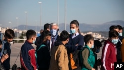 Greek Prime Minister Kyriakos Mitsotakis, right, and German Ambassador to Greece Ernst Reichel, attend the departure of a group of migrant minors from Greece to Germany, at Eleftherios Venizelos International Airport in Athens, April 18, 2020.