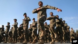 FILE - Newly-graduated Afghan National Army personnel march during their graduation ceremony after a three month training program at the Afghan Military Academy in Kabul, Afghanistan, Nov. 29, 2020. 