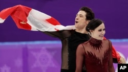 Tessa Virtue and Scott Moir of Canada celebrate during the venue ceremony after winning the gold medal in the ice dance, free dance figure skating final in the Gangneung Ice Arena at the 2018 Winter Olympics in Gangneung, South Korea, Feb. 20, 2018.