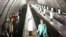 People wearing face masks and gloves to protect against coronavirus observe social distancing guidelines as they go down the subway on the escalator in Moscow, Russia, May 12, 2020.