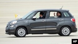 FILE - Pope Francis waves from inside a Fiat 500L as he departs Andrews Air Force Base in Maryland, Sept. 22, 2015. One of the two Fiats used by Pope Francis during his visit to Philadelphia last year is going up for auction. 