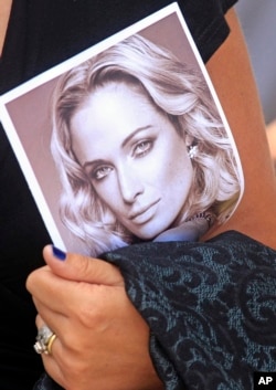FILE - A mourner carries a program at the funeral for Reeva Steenkamp in Port Elizabeth, South Africa, on Feb. 19, 2023. Her boyfriend, Oscar Pistorius, was convicted in her killing and will be released on parole on Jan. 5, 2024.