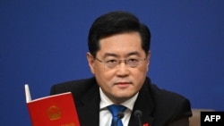 资料照：中国前外交部长秦刚在一个记者会上手拿一本中国宪法。(2023年3月7日)