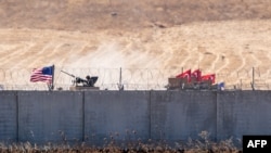 FILE - U.S. and Turkish armored vehicles take part in their first joint patrol with Turkey under a deal reached between Washington and Ankara, at the border with Syria near Akcakale, in the Sanliurfa province of Turkey, Sept. 8, 2019. 