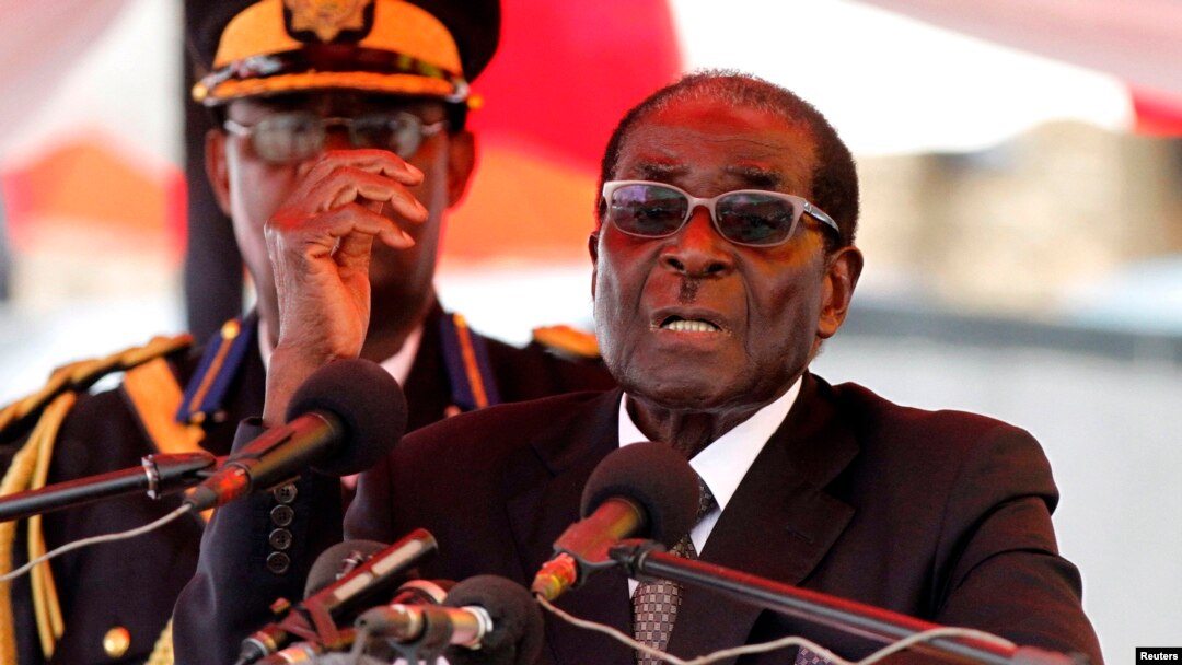 Zimbabwean President Robert Mugabe gestures as he addresses mourners gathered for the burial of Vice-President John Nkomo at National Heroes Acre, in Harare, Zimbabwe, January 21, 2013.