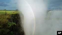 FILE - In this April 1995, file photo, a rainbow forms in a cloud of mist over the Victoria Falls, Zimbabwe. 