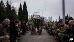 Militares ucranianos del batallón Khartia cargan el ataúd de Vladyslava Chernyh "Aida" durante una ceremonia fúnebre en el cementerio de Kharkov, Ucrania, el viernes 30 de diciembre de 2022.