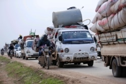 FILE - In this Jan. 29, 2020 file photo, Syrians flee the advance of government forces towards the Turkish border, in Idlib province, Syria.