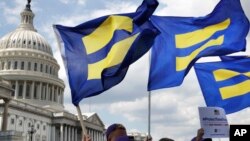 人权活动人士举着“平等旗”聚集在国会山，声援跨性别军人。（2017年7月26日）