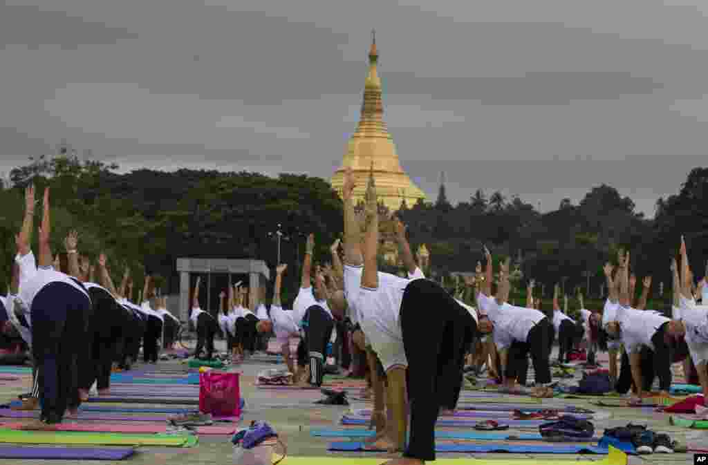 在缅甸仰光的仰光大金寺或称雪德宮大金塔（ Shwedagon pagoda）旁边，瑜伽爱好者们专心练习（2017年6月21日）