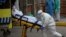 A member of the health staff team wearing a protective suit to protect against coronavirus, transfers a patient into an ambulance at the Severo Ochoa hospital in Leganes, outskirts of Madrid, Spain, April 7, 2020. 