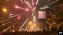 Anti-government protester shoots a firework to riot police during a protest in Bangkok, Thailand, Aug. 15, 2021.