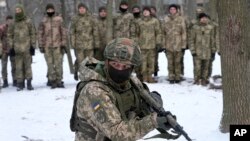 An instructor trains members of Ukraine's Territorial Defense Forces, volunteer military units of the Armed Forces, in a city park in Kyiv, Ukraine, Saturday, Jan. 22, 2022. (AP Photo/Efrem Lukatsky)