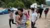 Hondureños que participan en una nueva caravana de migrantes que se dirigirá a los Estados Unidos, caminan cerca del paso fronterizo de Corinto con Guatemala, en Corinto, Honduras, 30 de marzo de 2021.