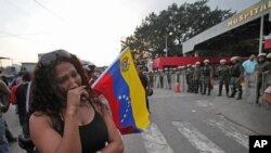 Una mujer llora en las afueras del hospital militar donde murió Chávez. Los restos del ex mandatario serán trasladados a la Academia Militar.