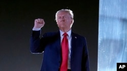 FILE - Republican presidential nominee former President Donald Trump gestures as he concludes speaking at a campaign event at the Butler Farm Show, in Butler, Pennsylvania, Oct. 5, 2024.