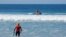 FILE- lifeguards watch over the waters off Beacon's Beach after authorities said a young boy was attacked by a shark in Encinitas, California, Sept. 29, 2018. 26-year-old man was killed in a shark attack on May 9, 2020, while surfing near Monterey Bay.